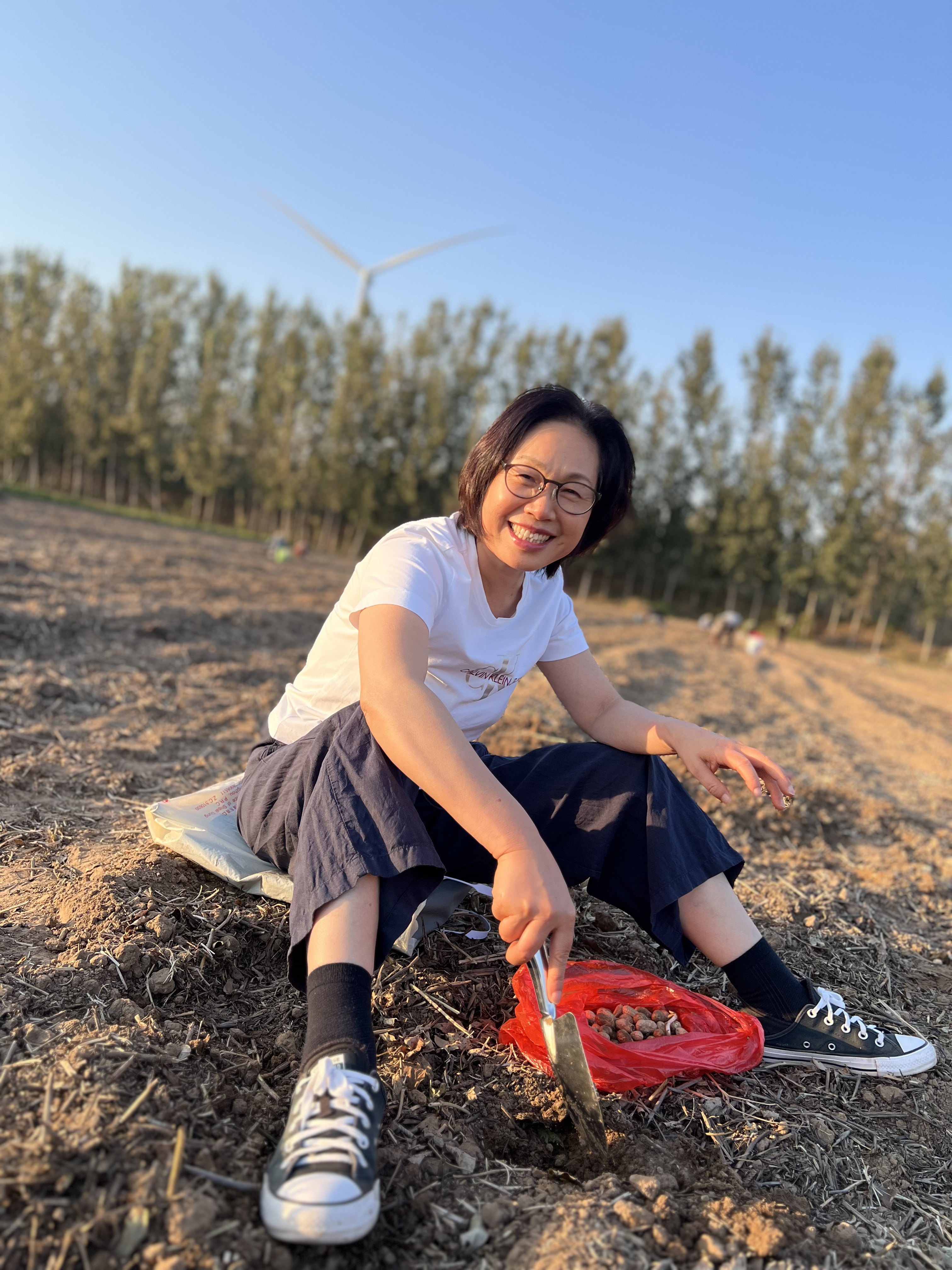 坐在田间播种的人，回头微笑